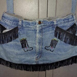 Denim mini skirt with fringe and embroidered cowboy boots design.