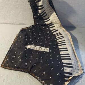 A piano-shaped black and white bag with a music note pattern.