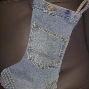 A Christmas stocking made from denim jeans fabric with a back pocket design.