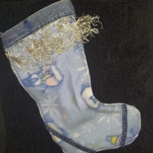 A worn blue baby sock with a frayed top and faded patterns.