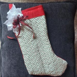 A festive Christmas stocking with a red cuff and decorative bow.