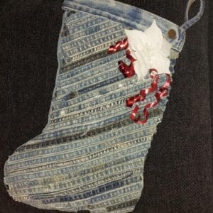 A denim Christmas stocking with red and white decorations.