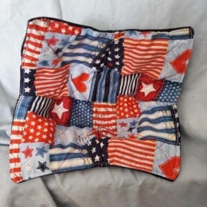 Patchwork cushion with American flag designs in red, white, and blue.
