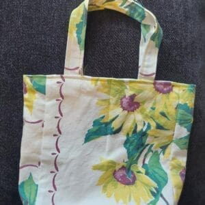 Floral-patterned tote bag with green and yellow flowers on a light background.